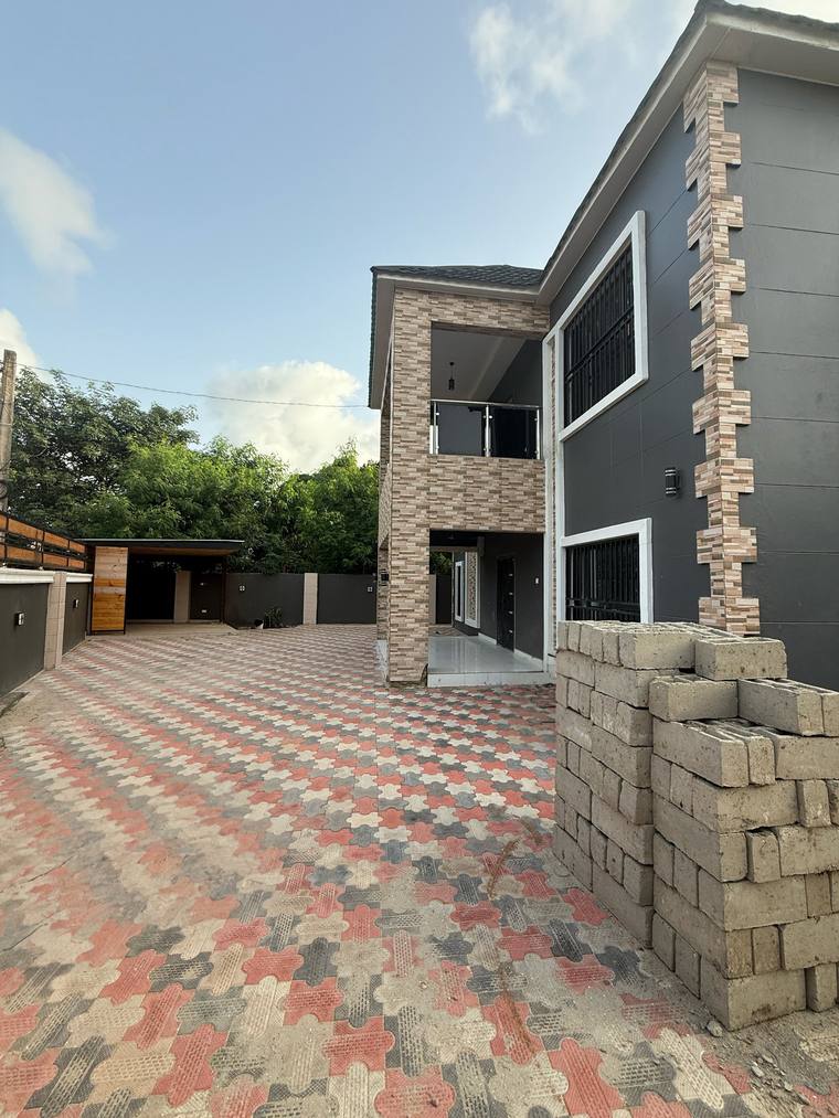 The side of the house from the paved forecourt, showing the depth of the two-storey elevation.