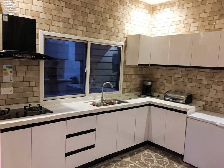 The fitted kitchen, with built-in units, tiled splashback and a worktop running the length of the wall.